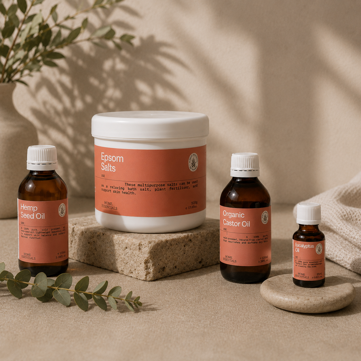four products of our Body Ache collection, gathered in a warm environment including eucalyptus branch and body towel