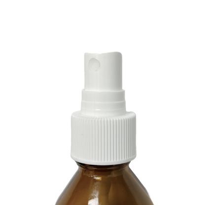 Home Essentials mist pump head fitted onto an amber glass bottle, showing the spray nozzle and ribbed screw cap in use.