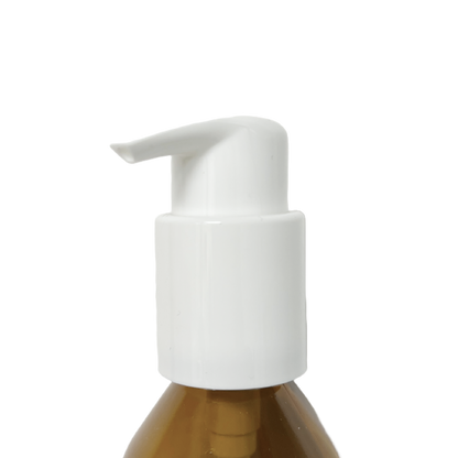 Pump dispenser head fitted onto an amber glass bottle, close-up view